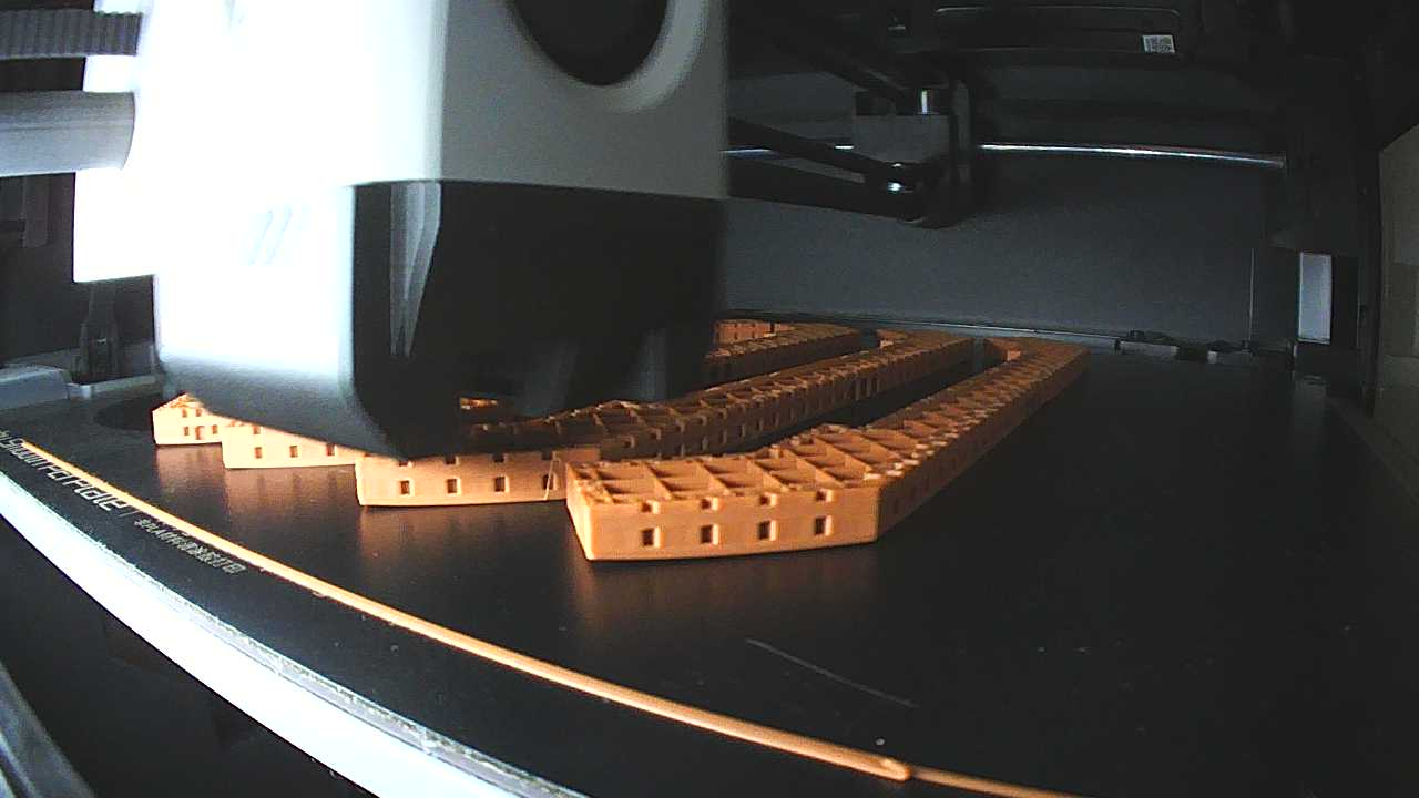 The camera stream: brown building models with corners lifted off the bed